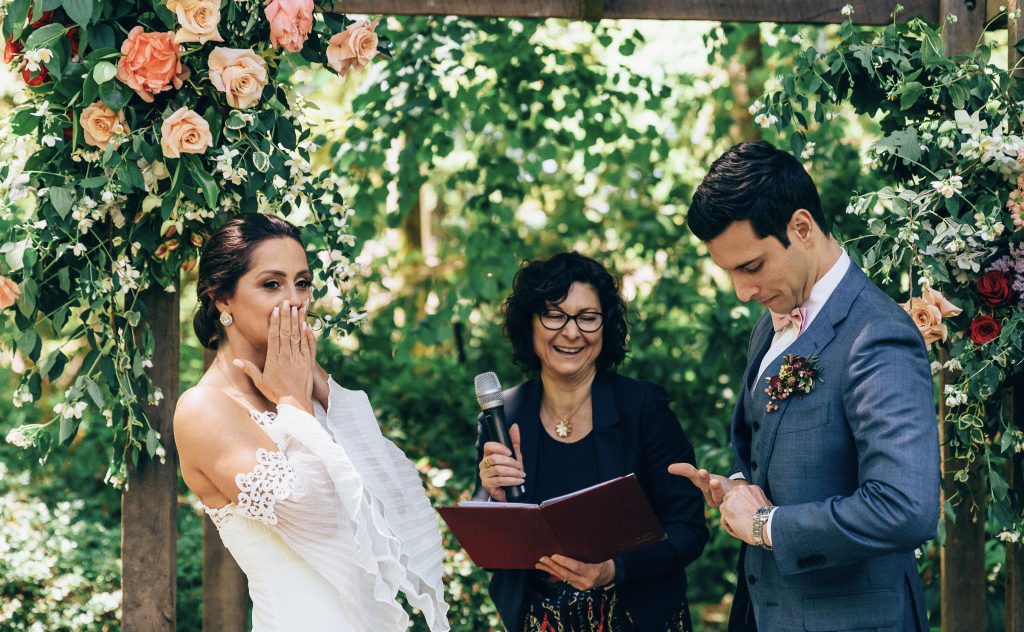 Blue Mountains wedding celebrant reading a ceremony to a couple in a leafy garden