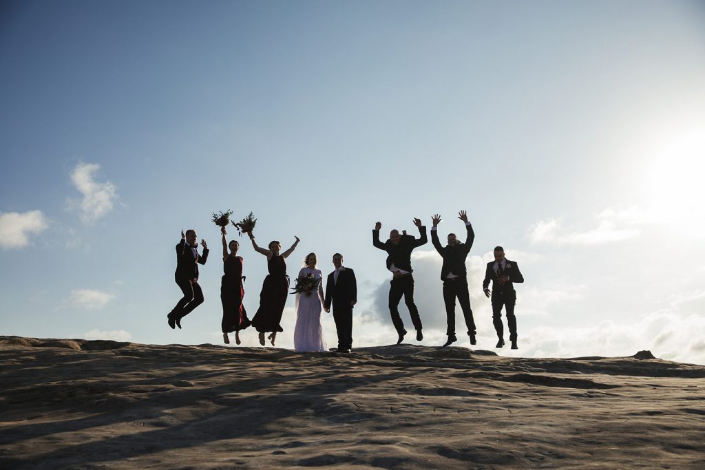Wedding party jumping for joy on a clifftop in the Blue Mountains